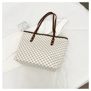 Detailed view of large capacity women tote bag with vintage geometric print and brown leather handles.