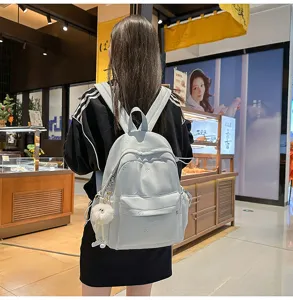 Hellblauer Rucksack Detailansicht mit süßer Schleifenstickerei und Anhänger für den Alltag.