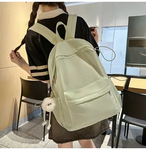 Hellgrüner Schulrucksack mit süßer Schleifenstickerei und einem flauschigen Monsteranhänger.