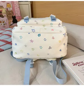 Schöner weißer Canvas-Rucksack mit bunten Sternen und blauen Trägern für Mädchen.