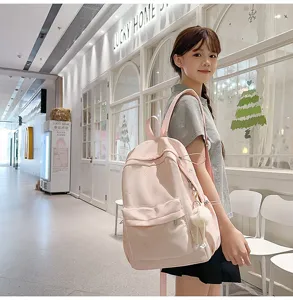 Süßer rosa japanischer Rucksack mit süßen Schleifendetails und flauschigem Plüschanhänger.