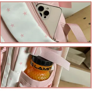 Rosa-weißer Rucksack mit Sternenmuster im Detail, zeigt funktionale Fächer und Taschen.