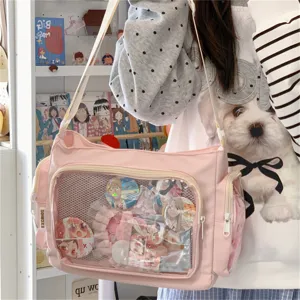Detailansicht der rosa Itabag mit transparentem Fach, Canvas Umhängetasche mit Ansteckern.