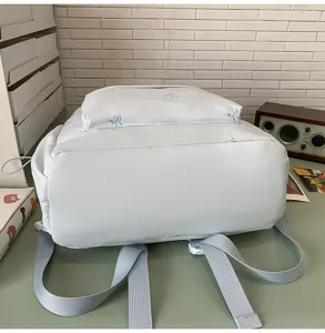 Detailansicht des süßen hellblauen Schülerrucksacks mit niedlicher Schleifenstickerei.