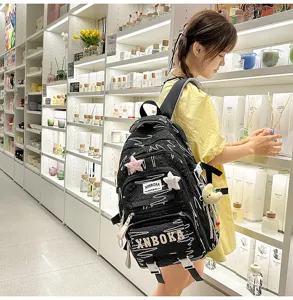 Klassischer schwarzer Schulrucksack mit mehreren Fächern und niedlichen Anhängern.