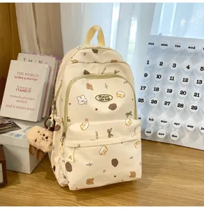 Süßer Cartoon bedruckter Canvas Rucksack für Mädchen, modische Schultasche mit Plüschanhänger.