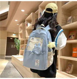 Detailansicht des hellblauen Canvas-Schulrucksacks mit Kontrasttaschen und Sternanhängern.