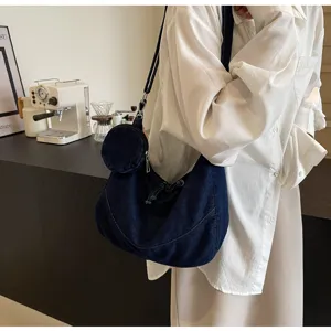 Dark blue denim hobo dumpling crossbody bag detail, casual soft shoulder purse with pouch.