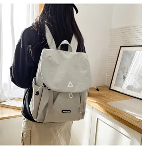 Casual grey backpack for women, large capacity travel school bag with secure flap design.