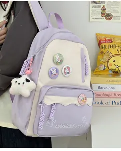 Hübscher pastelllila Studentenrucksack mit großer Kapazität, süßen Badges und Plüschanhänger.