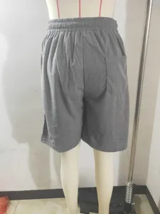 Men's corduroy drawstring shorts detail view, featuring back pocket and soft texture.