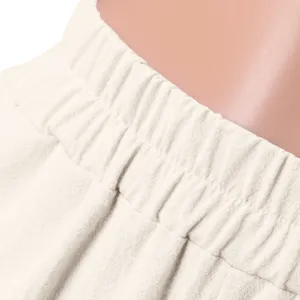 Close-up detail of women's casual wide leg trousers elastic waist solid color fabric.