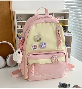 Detailansicht des süßen rosa-gelben ästhetischen Rucksacks mit Ansteckern und Plüschanhänger.