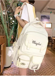 Details des koreanischen einfarbigen Canvas-Rucksacks mit vielen Taschen und Plueschanhaenger.