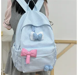 Nahaufnahme des hellblauen karierten Schulrucksacks mit süßen Schleifen für den täglichen Gebrauch.