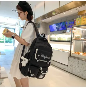 Detailansicht eines stylischen schwarzen Rucksacks mit Fächern und niedlichem Hasen-Anhänger.