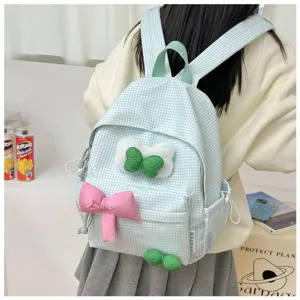 Detailansicht des hellgrünen Karorucksacks mit flauschigen Schleifen und rosa Schleifendetails.
