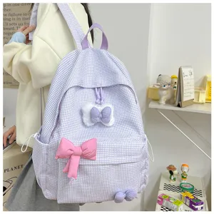 Nahaufnahme des süßen lila karierten Studentenrucksacks mit schönen rosa Schleifen.