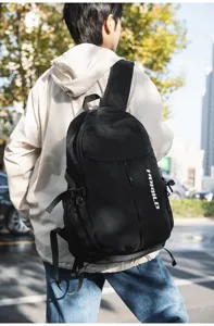 Dettaglio di uno zaino casual nero all'aperto, con nylon resistente e tasca a rete laterale.