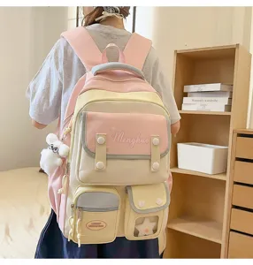 Detailansicht des süßen Pastell-Schulrucksacks mit mehreren Fronttaschen und weichem Anhänger.