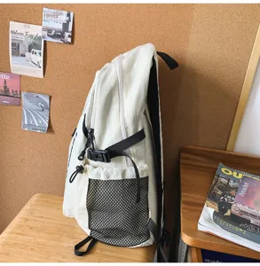 Zaino minimalista tinta unita con tasca in rete, borsa scolastica versatile per uso quotidiano.