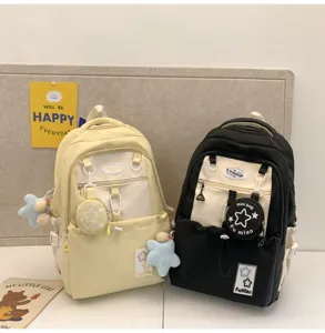 Detailansicht des farbblockierten Rucksacks für Schüler mit Minipäckchen und Sternanhänger.