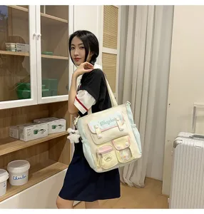 Detailansicht der Segeltuchtasche mit mehreren Taschen, niedlichem Plüschanhänger und Stil.