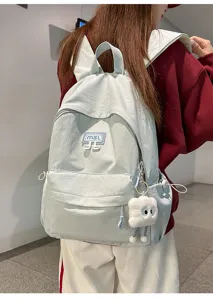 Detailansicht des mintgrünen lässigen Studentenrucksacks mit Taschen und süßem Anhänger.