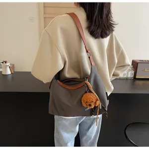 Lässige Canvas Umhängetasche für Damen, geräumiges Design mit niedlichem Pudel Plüsch-Anhänger.