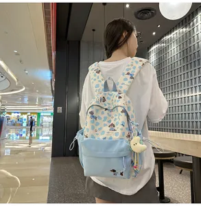 Detailansicht des niedlichen blauen Rucksacks mit Hundemotiv, getragen vom Model im Innenbereich.