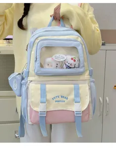 Detailaufnahme des farbblockierten Ita-Rucksacks mit transparentem Fach und Stofftieren.