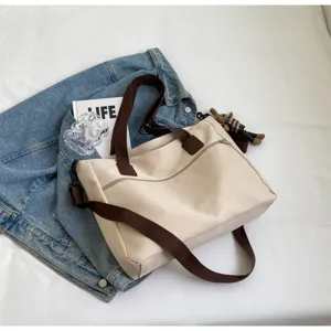 Leinwand Shopper Detailansicht, lässige beige Umhängetasche mit braunen Riemen und Reißverschluss.