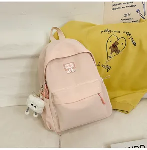 Detaillierte Ansicht des rosa Schülerrucksacks mit niedlichem Plüsch-Anhänger und Vordertasche.