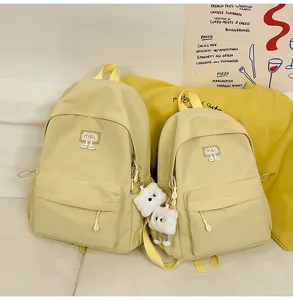 Detailansicht des gelben Schülerrucksack-Sets mit Vordertasche und süßem Plüschanhänger.