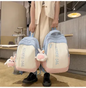 Detailansicht des farbblockierten Mini-Rucksacks mit süßem Plüsch-Kaninchenanhänger und Vorderdruck.