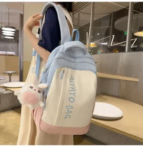 Detailansicht mit der vorderen Tasche des farbblockierenden Mini-Rucksacks und Anhänger.