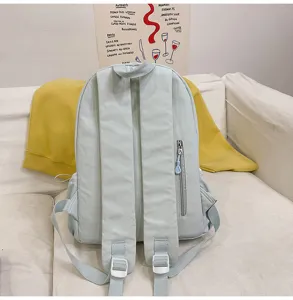 Detailaufnahme eines hellgrünen minimalistischen Freizeitrucksacks mit Reißverschlusstasche.