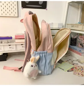 Detailansicht des niedlichen, farbblockierten Mini-Rucksacks mit Fächern und Plüschtier.