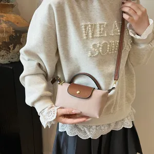 Mini-Umhängetasche mit brauner Lederklappe und stilvollem rosa Stoffkörper für den täglichen Gebrauch.