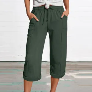 Close-up of dark green linen-blend cropped pants with elastic drawstring waist and side pockets.