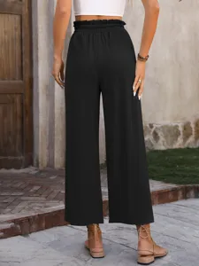 Outdoor detail shot showcasing a black high-waisted wide-leg trouser in casual style.