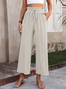 High-waisted wide-leg trousers detail shot, showing elastic drawstring waist and fabric texture.