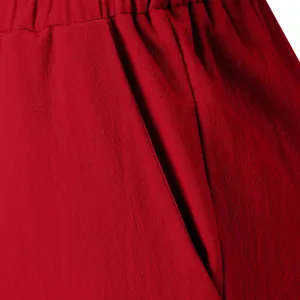 Detailed view of red cotton linen casual pants pocket and waistband, soft and breathable fabric.