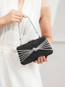 Detailansicht der eleganten schwarzen Satin Abendtasche mit funkelndem Strass Knoten und Kette.