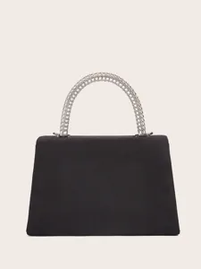 Elegant black velvet evening bag with unique silver metal grid handle, fine detail view.