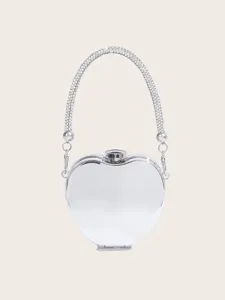 Nahaufnahme der silbernen Apfel-Abendtasche mit funkelndem Strassgriff und Metall-Finish.