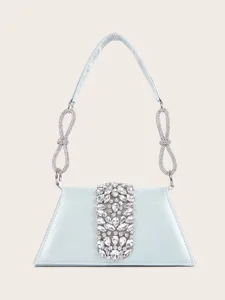 Nahaufnahme der funkelnden Strasssteine und der eleganten hellblauen Satin Abendtasche.