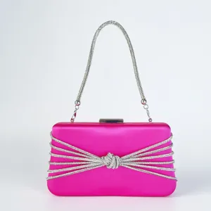 Detailansicht der eleganten rosa Satin Abendtasche mit funkelndem Strassknoten und Kette.