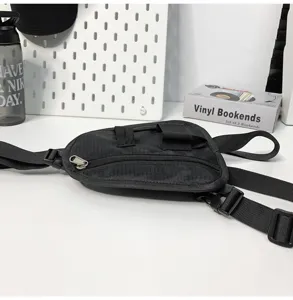 Vista di dettaglio borsa da petto tattica nera, marsupio utility streetwear multifunzionale.