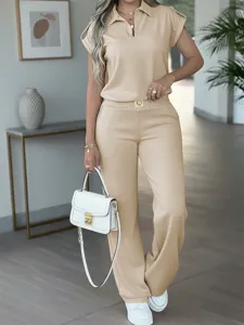 Detailed view of the casual beige short sleeve polo and wide leg trousers set in indoor scene.